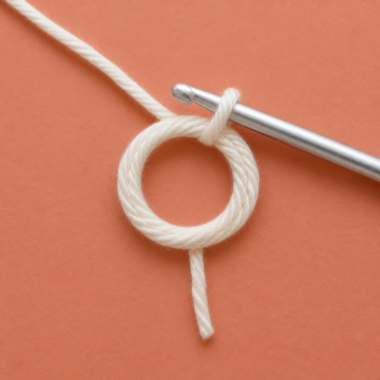 AI-assisted close-up of a crochet hook through an open magic ring, with working yarn and tail visibly separate.